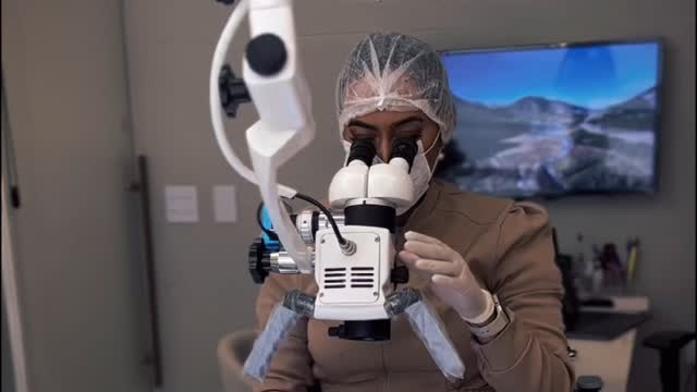 Dra. Larissa Operando com Microscópio